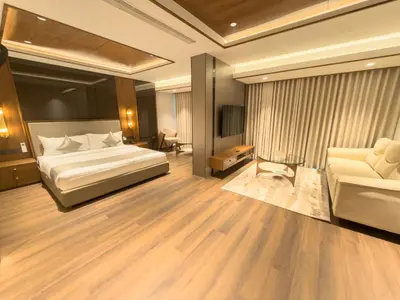 a large bedroom with a bed and a couch at Hotel Bluebell in Kozhikode