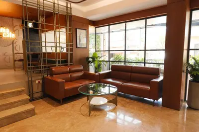 a living room with a couch and a table at Hotel Bluebell in Kozhikode