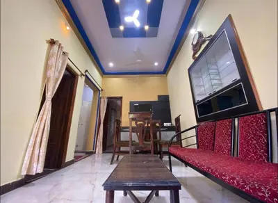a living room with a red couch and a flat screen tv at The bluebird residence in Mysore