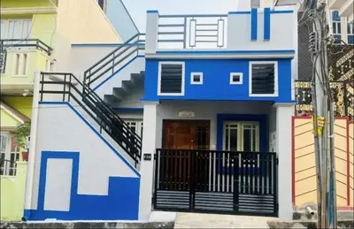 a blue and white house with a black gate at The bluebird residence in Mysore
