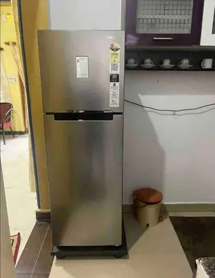 a stainless steel refrigerator in a kitchen with a microwave at The bluebird residence in Mysore
