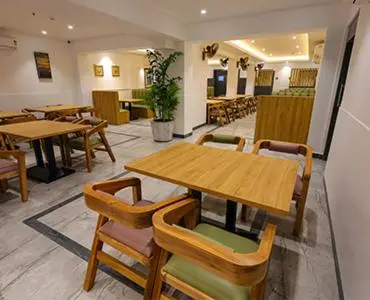 a dining room with wooden tables and chairs at HOTEL SR in Palani