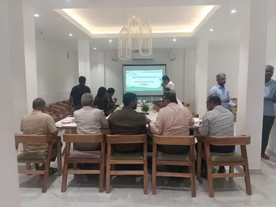 a group of people sitting around a table watching a presentation at HOTEL SR in Palani