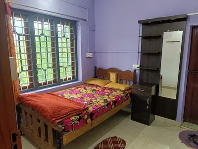 a bedroom with a bed and a dresser and a window at Paradise Homestays, Kanthalloor in Kanthalloor
