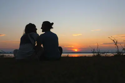 a couple sitting on the grass watching the sunset at Arasu Homestay in Antarasante