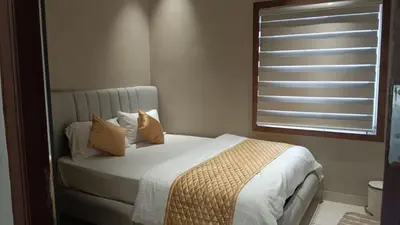 a bedroom with a bed with pillows and a window at Thulasi Avenue Inn in Pollāchi