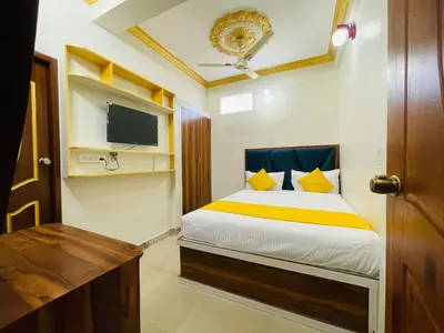 a bedroom with a bed and a tv in it at Hotel Boss Palace in Mysore