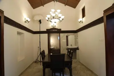 a dining room with a table and a chandelier at Pear Tree Luxe Entire 3BHK Villa - Only For Family in Kotagiri
