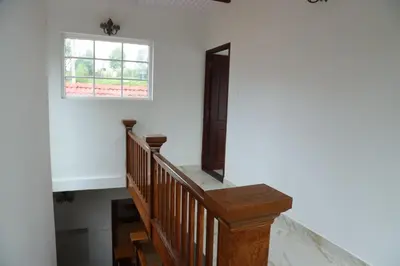 a wooden stairway with a window and a window at Pear Tree Luxe Entire 3BHK Villa - Only For Family in Kotagiri