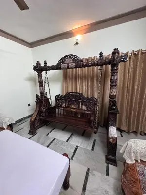 an antique bed in a room with a table at NAS VILLA in Mysore