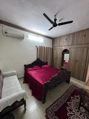 a bedroom with a red bed and a ceiling fan at NAS VILLA in Mysore