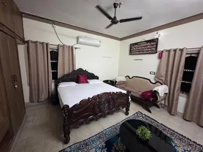 a bedroom with a large bed and a fan at NAS VILLA in Mysore