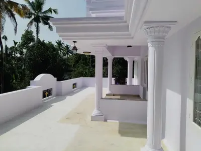 a white house with columns and a balcony at COZY Homes in Nedumbassery
