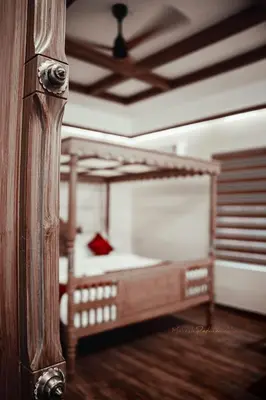 a bedroom with a wooden bed and a ceiling at ATHIRAPPILY SREENILAYAM HERITAGE RESORt in Athirappilly