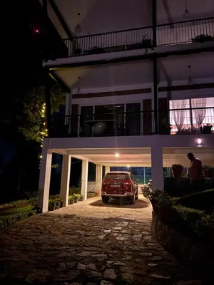 a car parked in front of a house at night at Tranquil Haven Kotagiri in Kotagiri