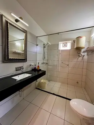 a bathroom with a sink and a toilet and a mirror at Tranquil Haven Kotagiri in Kotagiri