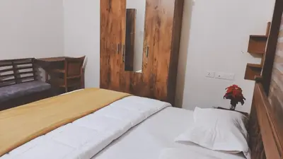 a bedroom with a large bed with a wooden door at UPPU HOMESTAY in Mulappilangād