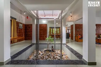 a room with a fish pond in the middle at StayVista at Lagoons Villa with Lawn, Pool, WiFi in Kozhikode