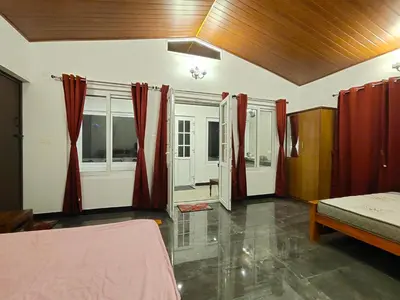 a bedroom with red curtains and a bed in a room at Silver Spruce Glass Villa 1BHK Kotagiri in Kotagiri