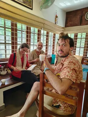 a group of three people sitting in a room at Ananda Holiday Home in Ambalavayal