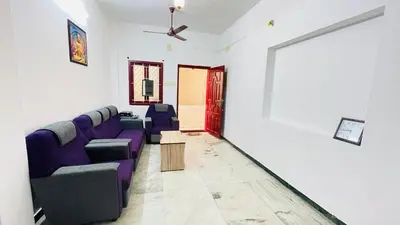 a living room with a purple couch and a table at White House - 2BHK - Esha Apartment in Coimbatore