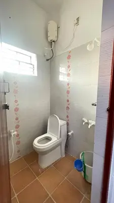 a small bathroom with a toilet and a window at White House - 2BHK - Esha Apartment in Coimbatore