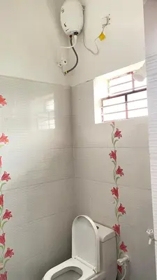 a bathroom with a toilet with flowers on the wall at White House - 2BHK - Esha Apartment in Coimbatore