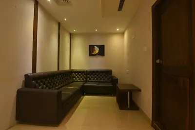 a waiting room with a leather couch and a table at THE DAWN HOTEL in Mysore