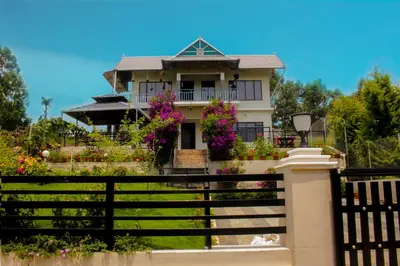 a house with a fence in front of it at Blue Lake in Kanthalloor