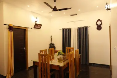 a dining room with a table and chairs and a clock at Le Serene in Meenangadi