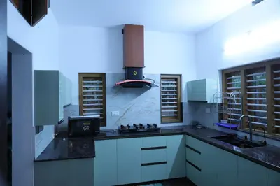 a kitchen with white cabinets and a stove at Le Serene in Meenangadi