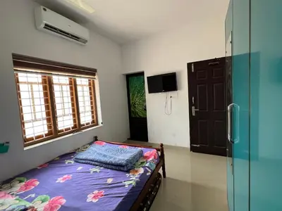 a small bedroom with a bed and a window at Happy Villa Homestay - 2 in Chelakara