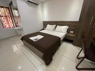 a bedroom with a bed and a television in a room at RK Residency Calicut in Kozhikode