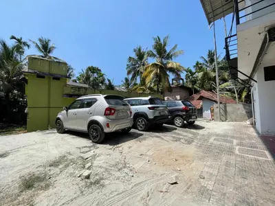 two cars parked in a dirt parking lot at RK Residency Calicut in Kozhikode