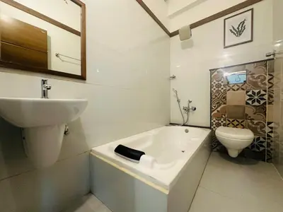 a bathroom with a sink and a tub and a toilet at Rio Rooms Calicut Near Mims Hospital in Kozhikode