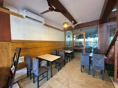 a dining room with tables and chairs in a restaurant at Rio Rooms Calicut Near Mims Hospital in Kozhikode