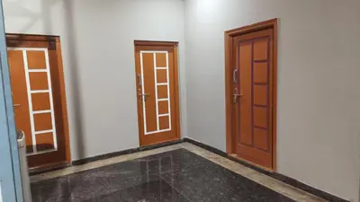 an empty room with two doors on the wall at AR premium family homestay in Mysore
