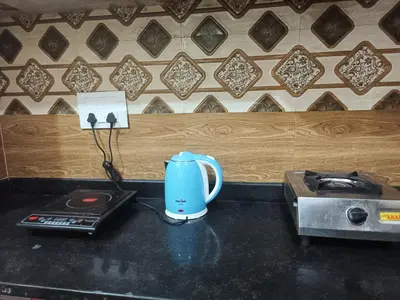 a blue tea kettle sitting on top of a kitchen counter at AR premium family homestay in Mysore