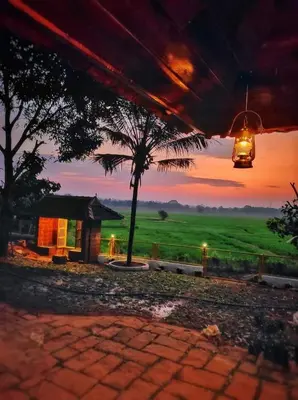 a view of a house with a palm tree and a sunset at Happy Land in Shoranūr