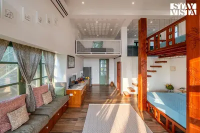 a room with a couch and a bed and a staircase at StayVista at Own The Beach Life - 1 BHK Pet Friendly - Beach View in Trichūr