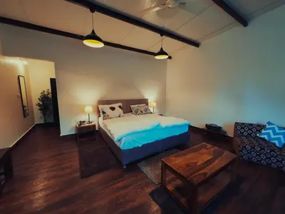 a bedroom with a bed and a couch and a table at Ooty Boulevard in Ooty