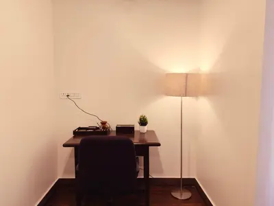 a desk with a chair and a lamp in a room at Ooty Boulevard in Ooty