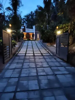 a walkway leading to a house at night at Aanandam - An Independent Villa in 1 Acre Farm in Wayanad