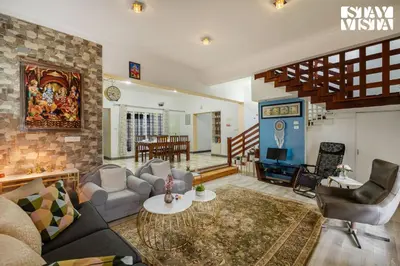 a living room with a couch and a tv at StayVista at Orion's Crest ooty including breakfast in Ooty