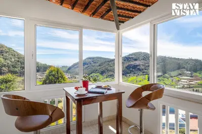 a room with a table and two chairs and windows at StayVista at Orion's Crest ooty including breakfast in Ooty