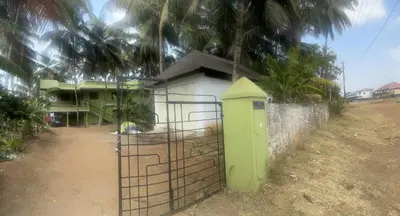 a building with a gate in front of a house at Lilly in Alattūr