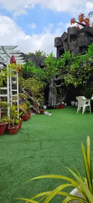 a garden with a table and chairs and plants at S & B Dreams House in Munnar