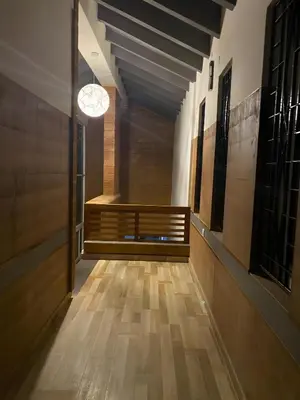 a hallway with a wooden floor and a light fixture at Red Rock Villa, Virajpet, Coorg in Virajpet