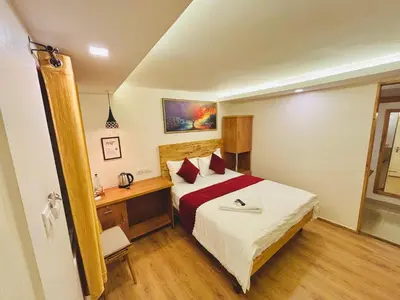 a bedroom with a bed and a desk in a room at RIO ROOMS Medical College in Kozhikode