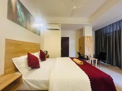 a bedroom with a large white bed with red pillows at RIO ROOMS Medical College in Kozhikode